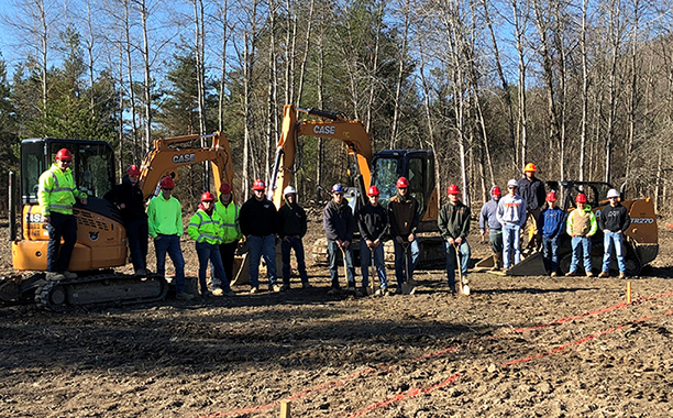 several students standing in front of heavy equipment