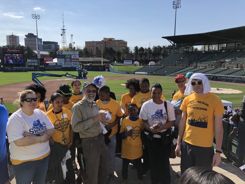 several people standing at a baseball field