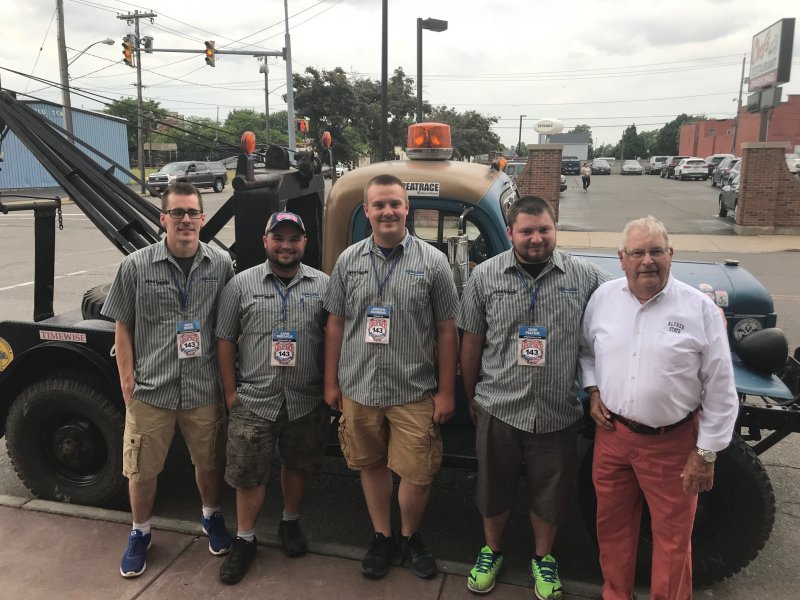 five people standing in front of a truck