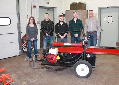 The students stand behind the log splitter they helped create.