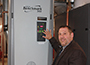 Senior Director of Facilities Services Glenn Brubaker poses with a new energy efficient satellite boiler