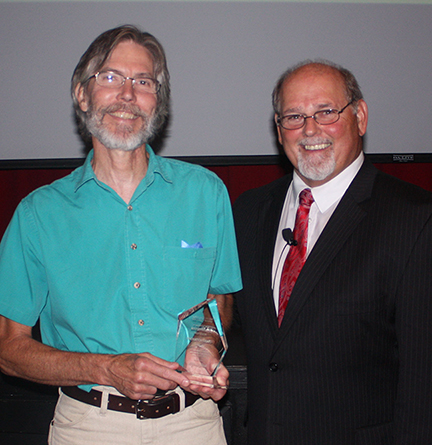 Mark Amman, holds Innovation Award presented to him by Dr. Skip Sullivan, right.