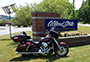 motorcycle in front of Alfred State sign on Wellsville campus