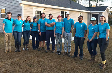 several students standing wearing blue shirts