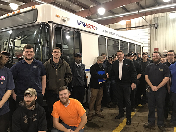 several students and instructors in front of bus