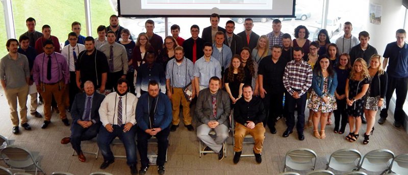 several students standing and sitting for a photo