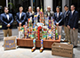 students wearing blue suite coats in front of cans of food