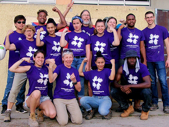 several students, faculty, and staff members wearing purple shirts