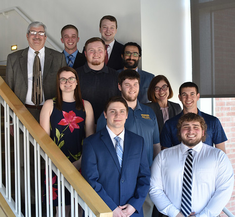 several people standing on the stairs smiling