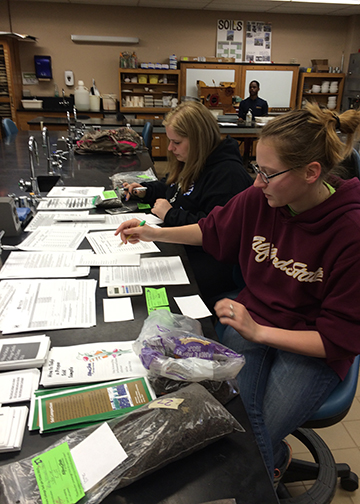 Two students work in soil class