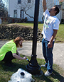 Juliana Krajewski and Abraham Kalamadeen paint a Victorian street light pole on Main Street 