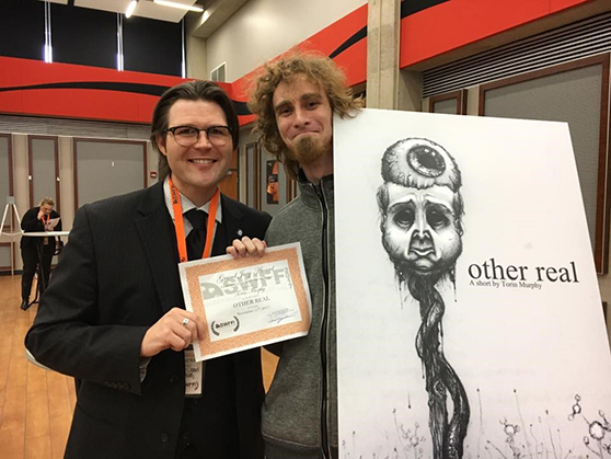 two males holding a certificate and a poster