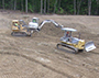 students driving bulldozers (2) and lots of dirt