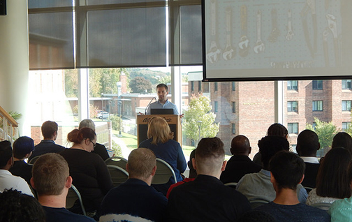 Darren Cotton, founder of University Heights Tool Library, speaking in front of an audience