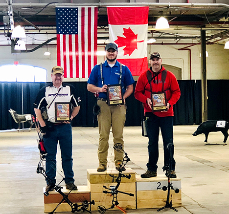 students holding trophies standing on blocks of wood