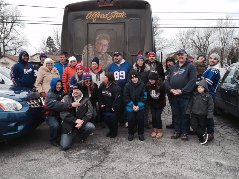 several people standing behind a bus