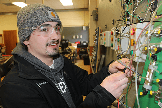 Eric holding on to some electrical wires on a board