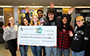students holding a big check