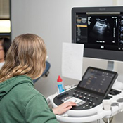 girl sitting in front of sonography equipment