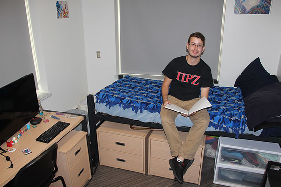 student sitting on a bed in MacKenzie