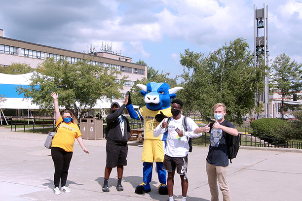 students outside waiving their hands in the air