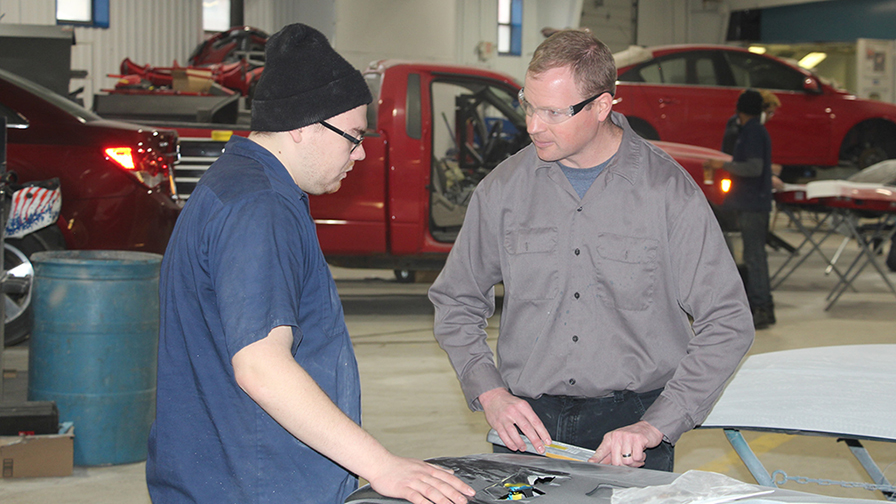 CJ Tremper on right in auto lab with a student