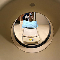 view inside computed tomography equipment with person on the other side