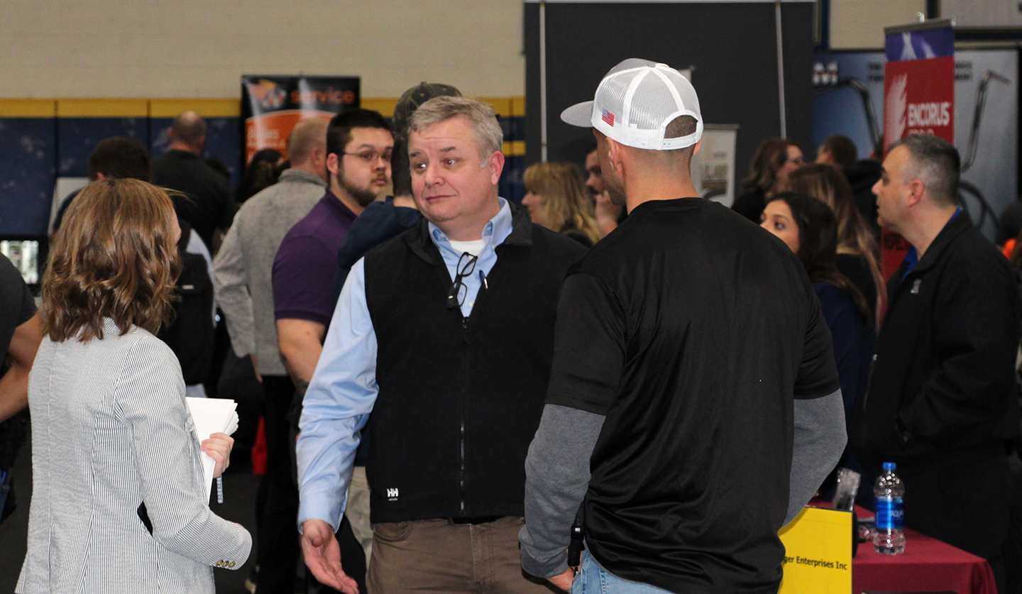 Employers talk to an Alfred State student about career opportunities at a past career fair.