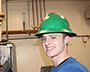 student with green hard hat on working on some wiring