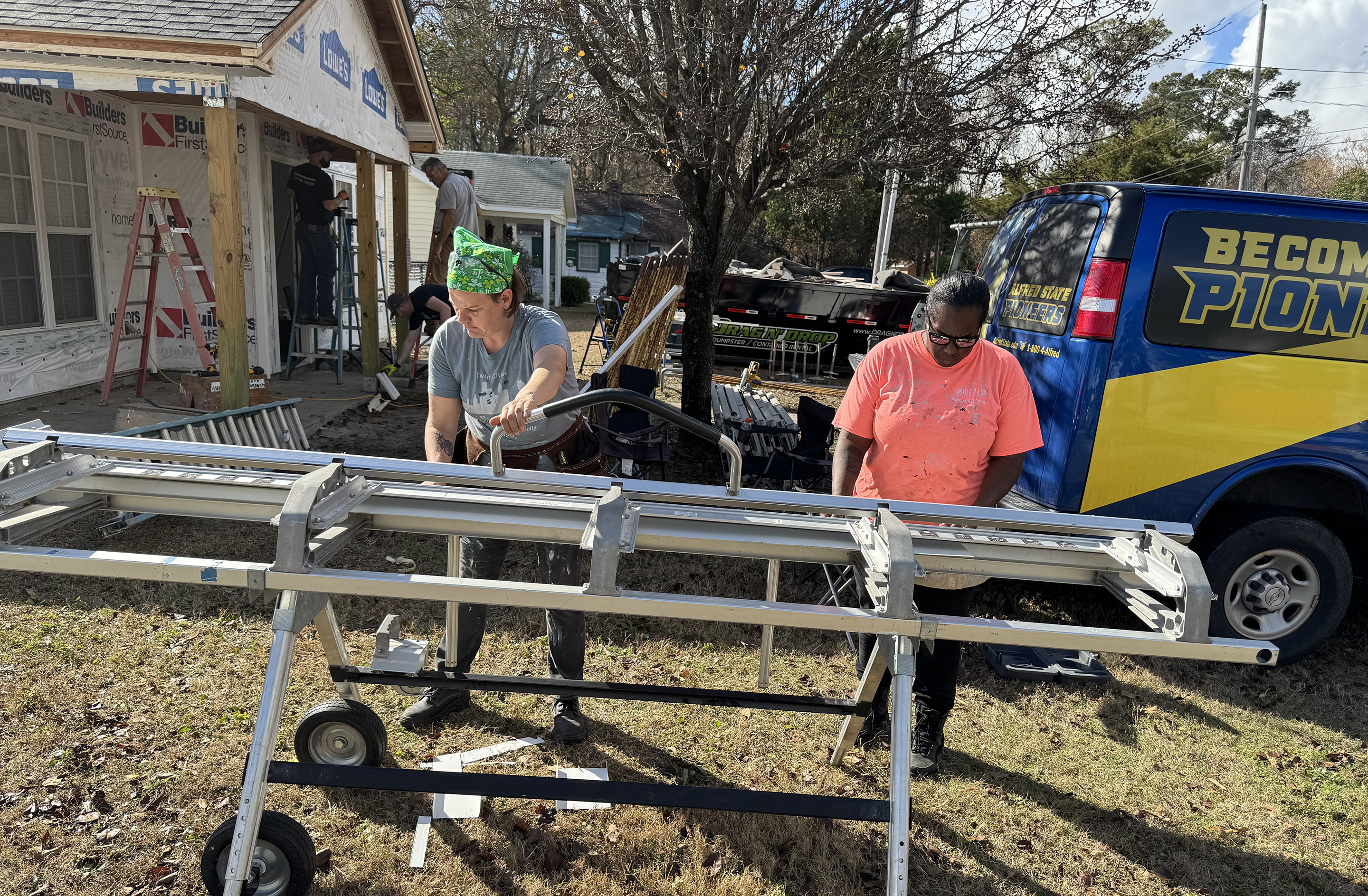 students work outside of a house with Habitat for Humanity