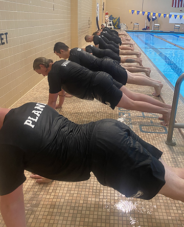 several recruits next to pool doing push ups