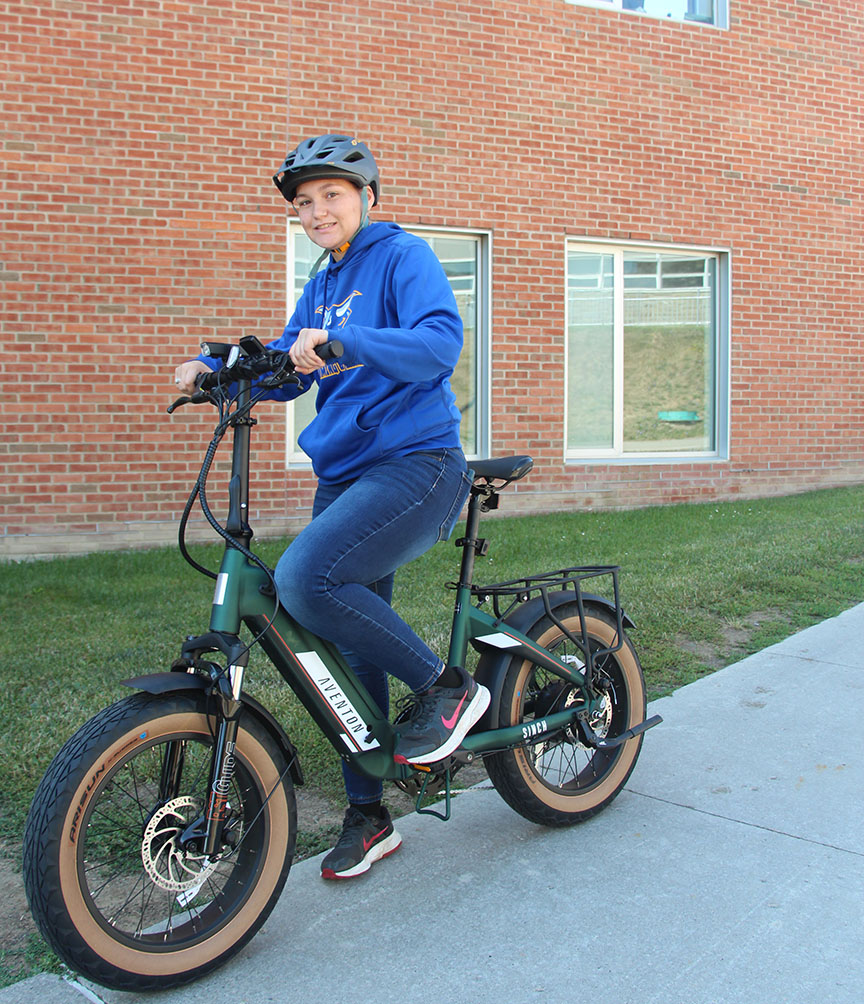 A student shows off one of the new electric bikes.