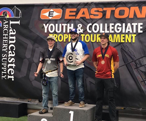 three men standing with awards