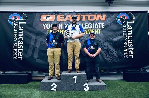 three men standing with awards