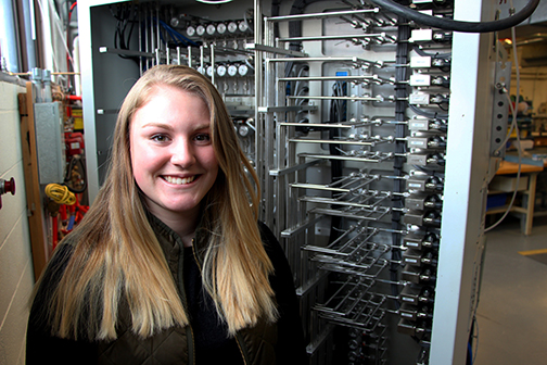 mechanical engineering technology student Allison DeGraff in front of some equipment