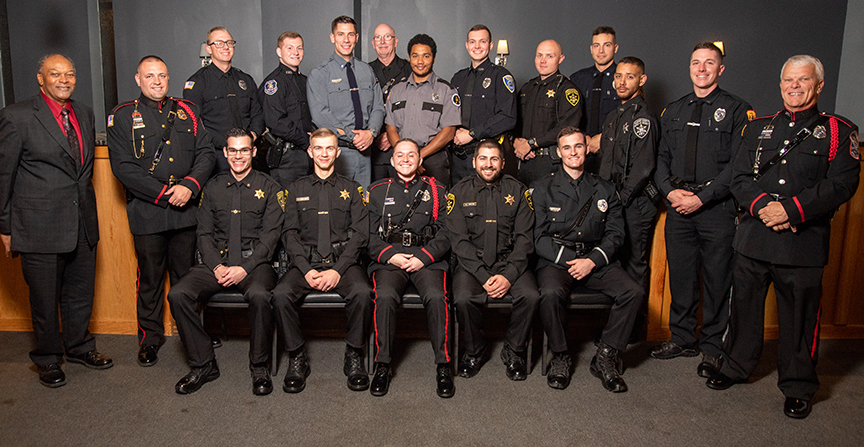 police academy students dressed up at their ceremony with instructors