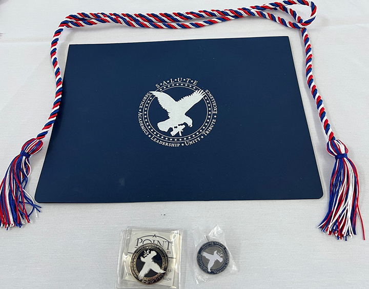 Certificate, honor cords, SALUTE pin, and challenge coin each inductee received.