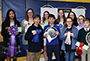 students holding their ribbons and awards