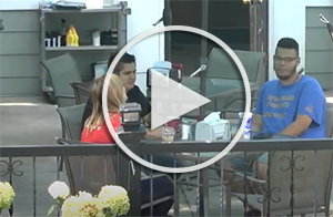 three students sitting at restaurant table outside, play button to youtube video