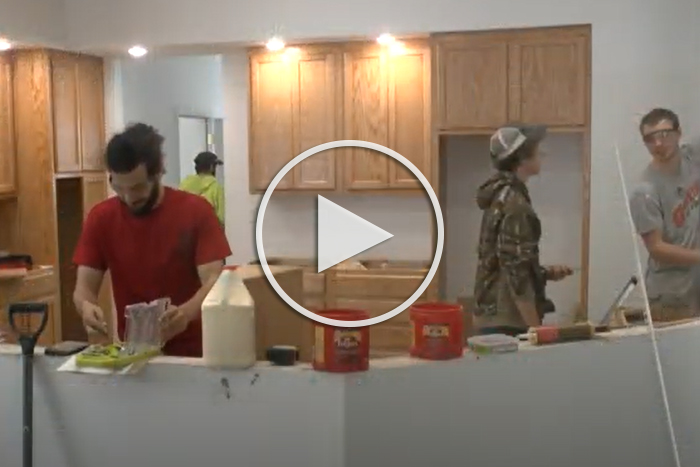 student building a kitchen, play button to YouTube video