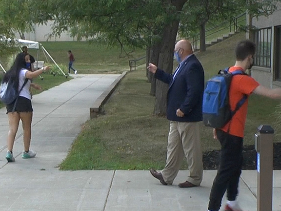 Skip pointing finger out toward a student on campus