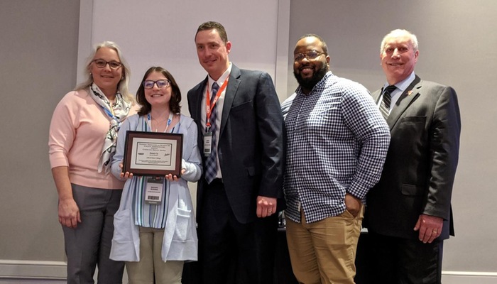 Alfred State representatives with an award at an NCAA convention