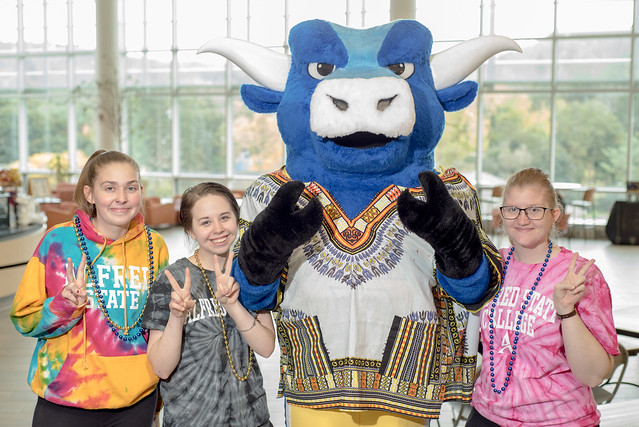 three students standing with Big Blue the ox