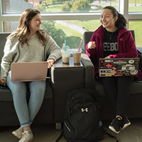 two students sitting with their laptops