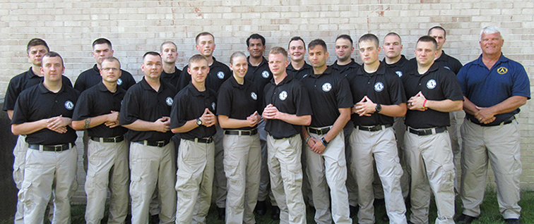 students in the police academy standing with their instructor