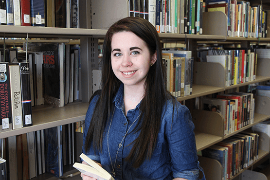 Kyra Hancock in front of a book case