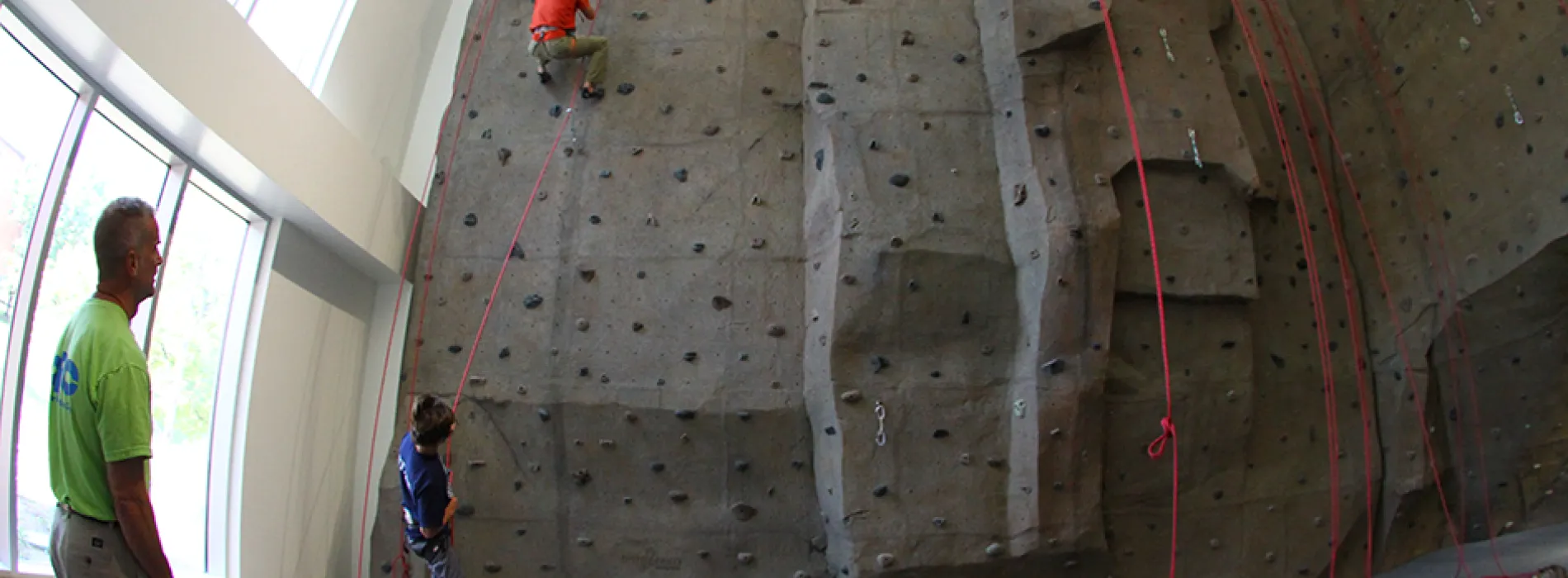 students climbing the rock climbing wall