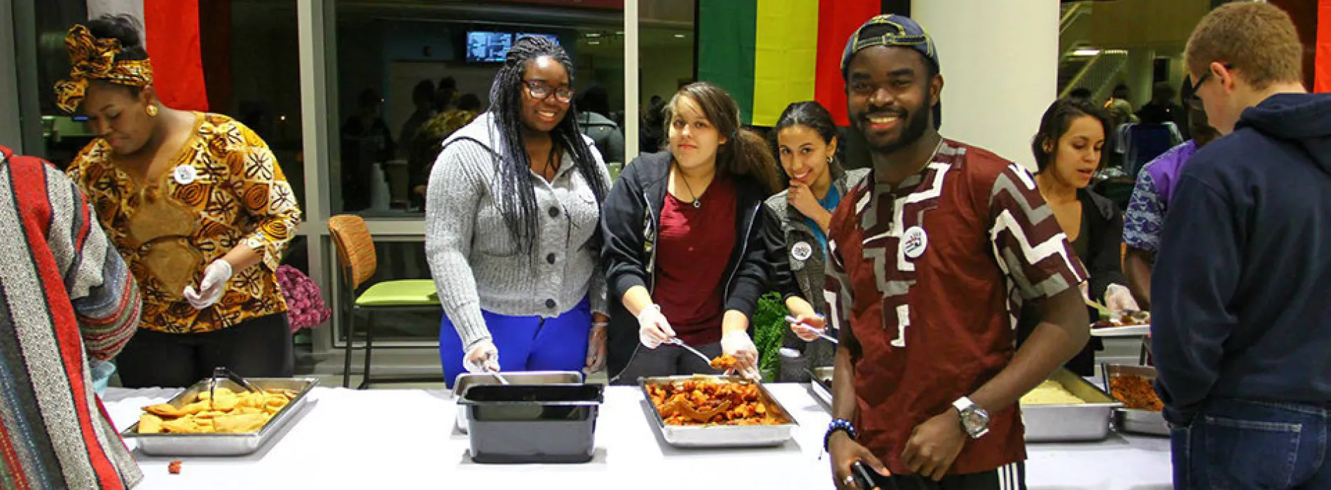 students serving food at a buffet line