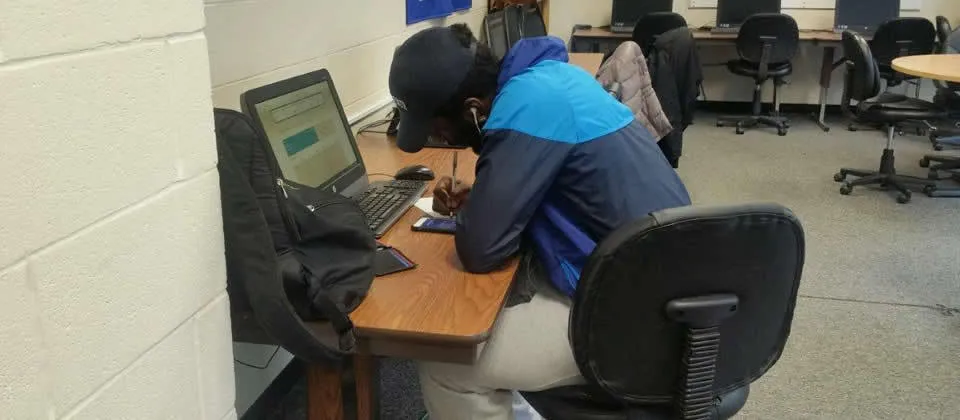 male student sitting at a computer