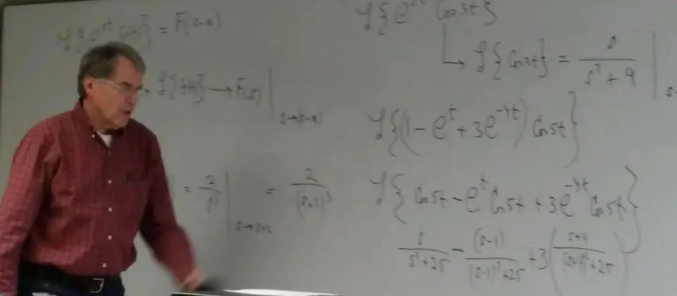professor in front of white board with writing